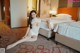 A woman sitting on the floor in a hotel room.