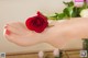 A woman's foot with a red rose on it.