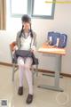 A woman sitting on a chair in a classroom.