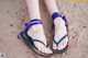 A close up of a person's feet wearing purple sandals.