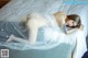 A woman laying on top of a bed covered in a veil.