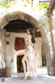 A woman in a long dress standing in an archway.