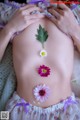 A pregnant woman with flowers on her belly. 