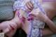 A woman laying on a bed holding a bunch of flowers.