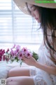 A woman in a straw hat holding a bunch of flowers.