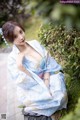 A woman in a blue and white kimono sitting on the ground.