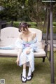 A woman in a blue kimono sitting on a white chair.