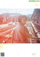 A woman standing on a train track next to a train station.