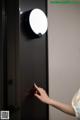 A woman is pressing a button on a door.