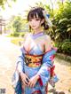 A woman in a blue kimono posing for a picture.