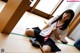 A woman in a school uniform sitting on the floor.