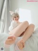 A woman in a bunny costume is sitting on a bed.