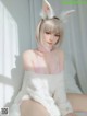 A woman in a bunny costume sitting on a bed.