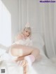 A woman in a bunny costume is sitting on a bed.