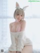 A woman in a bunny costume sitting on a bed.