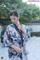 A woman in a blue and red kimono is posing for a picture.