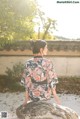 A woman in a kimono sitting on a rock.