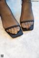 A close up of a woman's feet wearing black sandals.