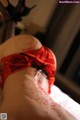 A woman in a red lingerie laying on a bed.