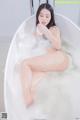 A woman sitting in a bathtub with foam on her body.