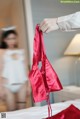 A person holding a red bra in front of a mirror.