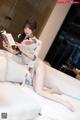 A woman sitting on a bed reading a book.