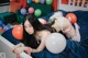 A woman laying on a bed with balloons around her.