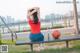 A woman sitting on a bench with a basketball.